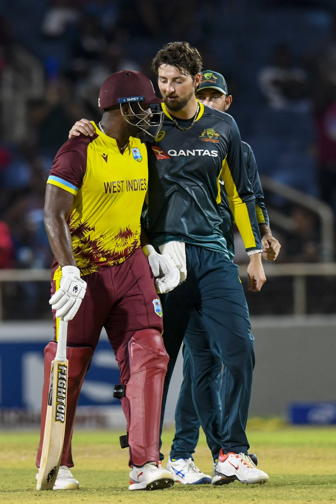 Andre Russell of West Indies (left) and Australia's Tim David (right) hug each other 